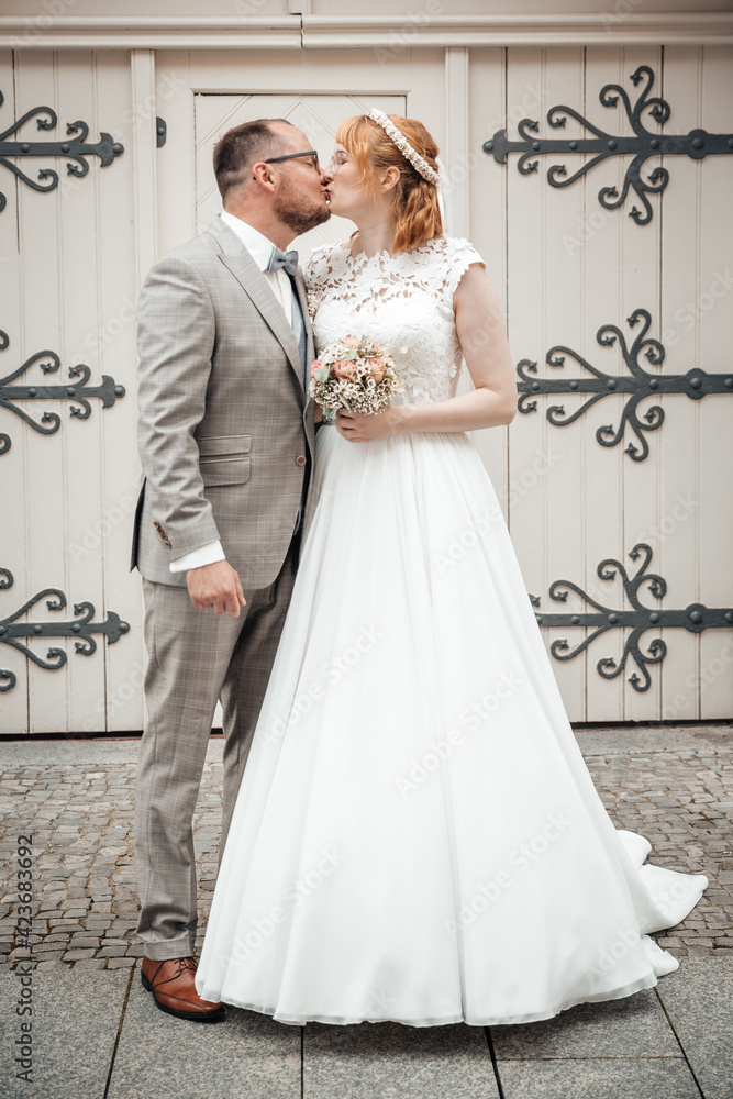 Groom and bride kissing on wedding day