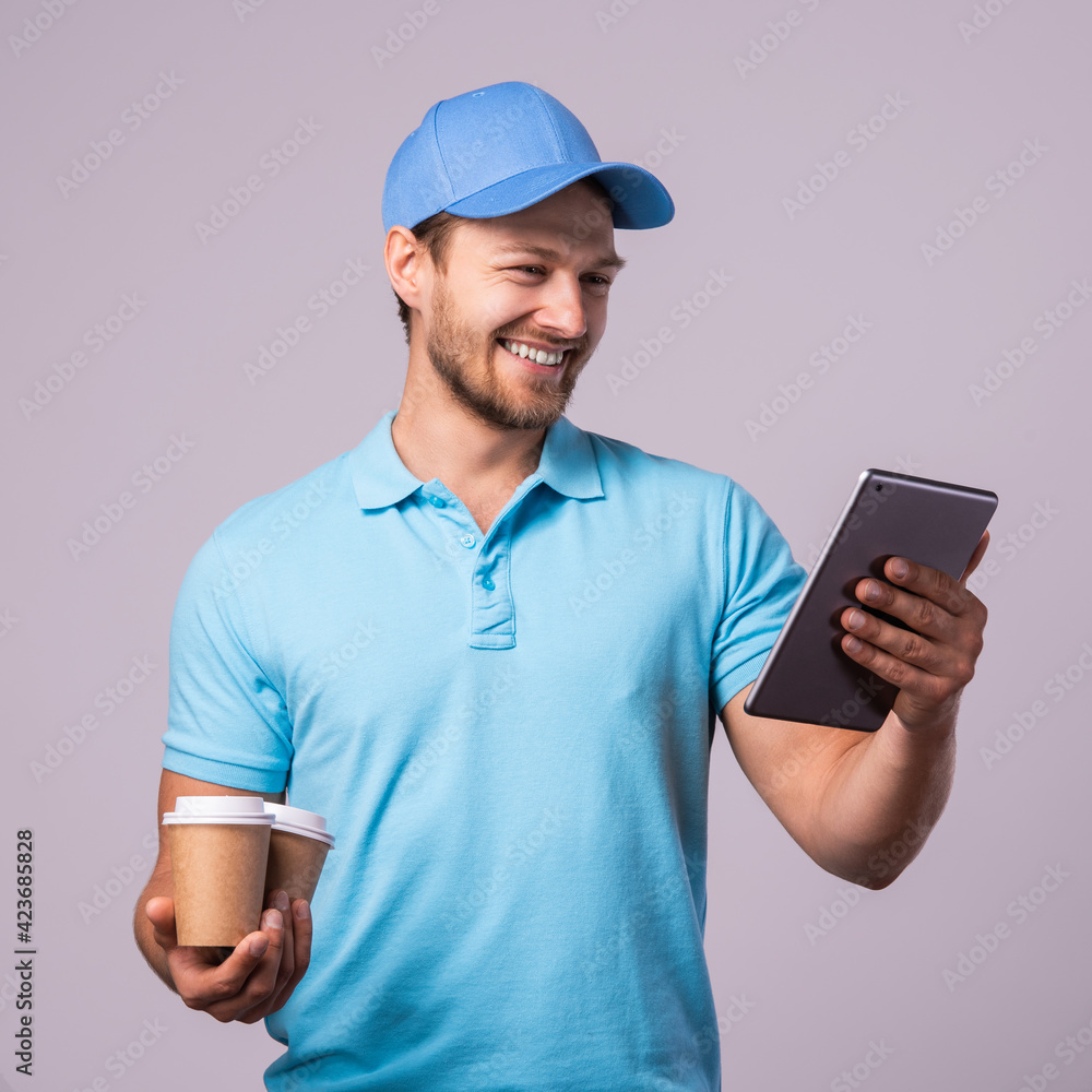 Delivery man is using tablet pc for navigation and brings two cups of coffee Delivery man is using tablet pc for navigation and brings two cups of coffee