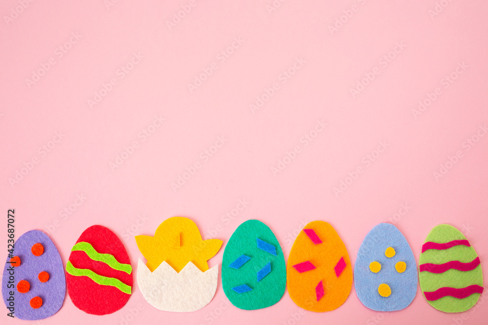 Happy Easter holiday concept. Cut out the felt applications of colorful eggs and the chicken hatched from the egg. Pink background. Flat lay. Copy space Happy Easter holiday concept. Cut out the felt applications of colorful eggs and the chicken hatched from the egg. Pink background. Flat lay. Copy space