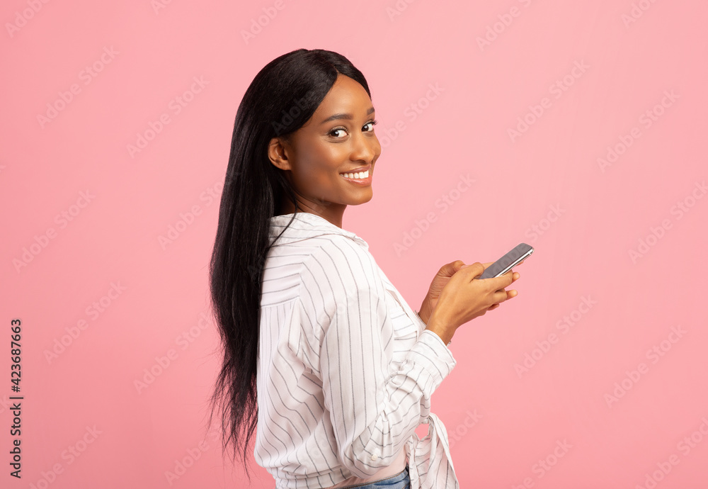 Young African American woman with smartphone talking to family or friends, having business meeting on pink background Young African American woman with smartphone talking to family or friends, having business meeting on pink background