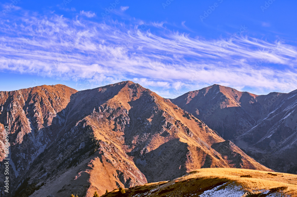 Majestic autumn mountains with spectacular clouds against the blue sky at sunrise