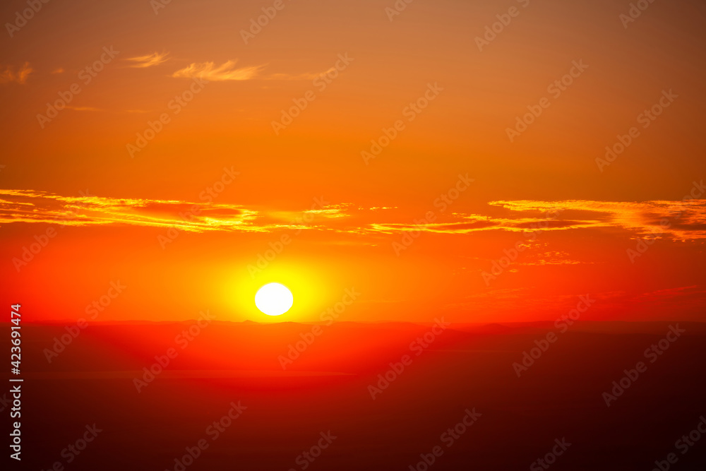 Setting sun over the mountain ridges as a background