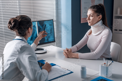 Injured woman with cervical collar in the doctor's office photo