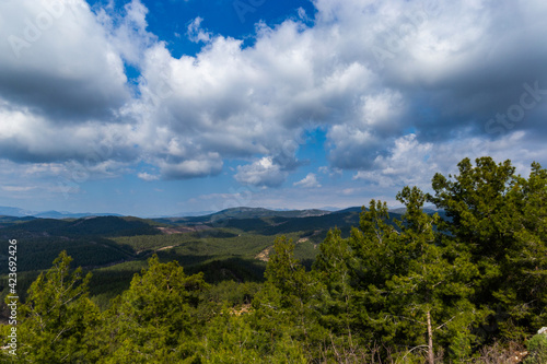 Summer landscape. Blue sky with clouds over the mountain ridge in the distance. © Sergey Fedoskin