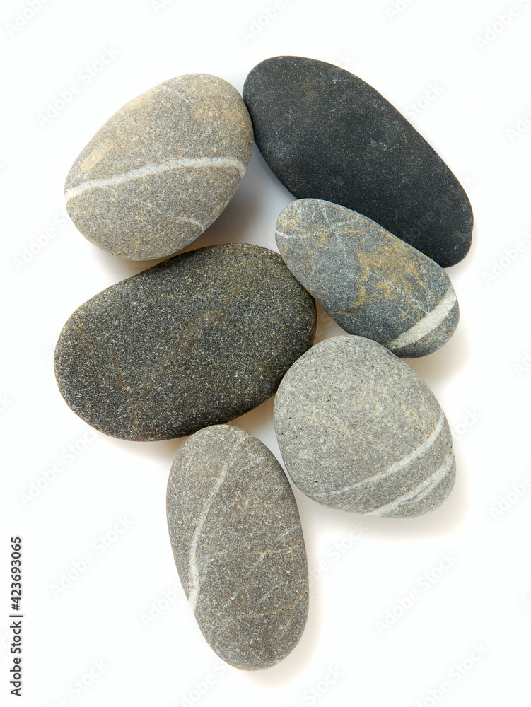 Grey pebbles isolated on white background. Grey sea stones with white stripes isolated on white. Studio shot. Grey pebbles isolated on white background. Grey sea stones with white stripes isolated on white. Studio shot.