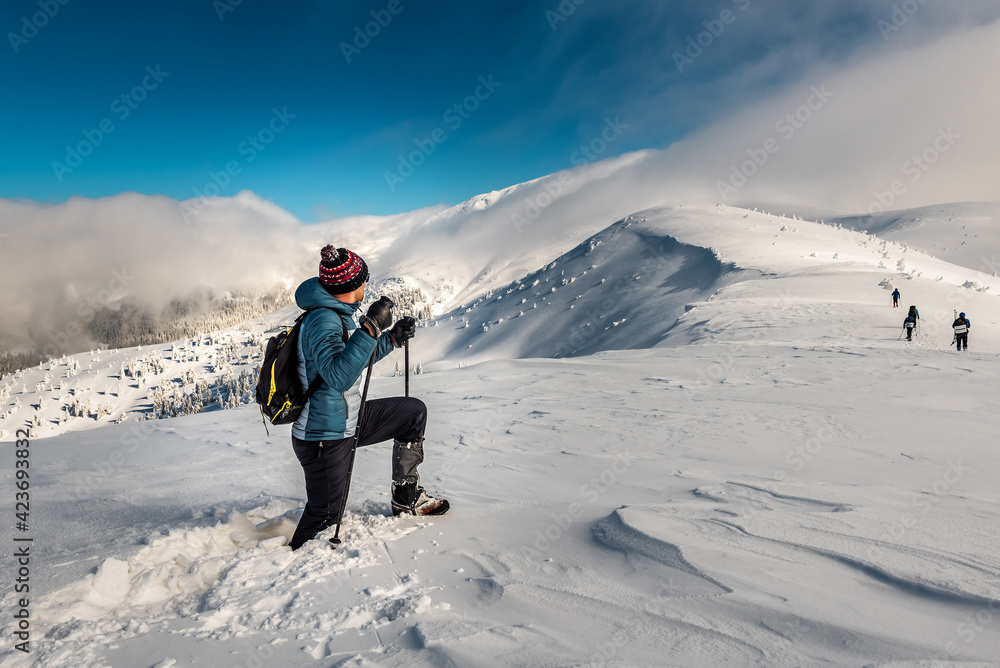 hiker walks on deep snow in the mountains