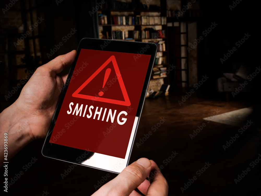 Smishing alert concept. Hands hold tablet with message. - obrazy, fototapety, plakaty 