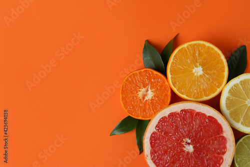 Fototapeta Naklejka Na Ścianę i Meble -  Ripe citrus with leaves on orange background