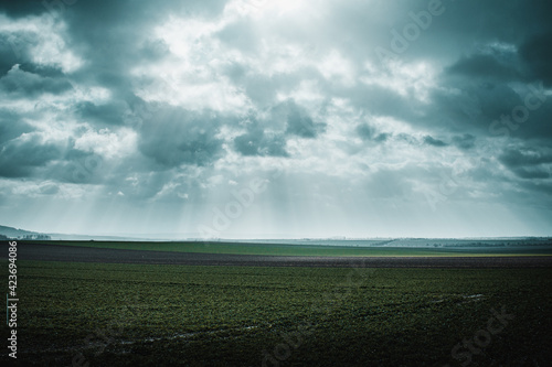 Dramatic spring nature with dramatic clouds and light rays and green countryside nature © Ricardo