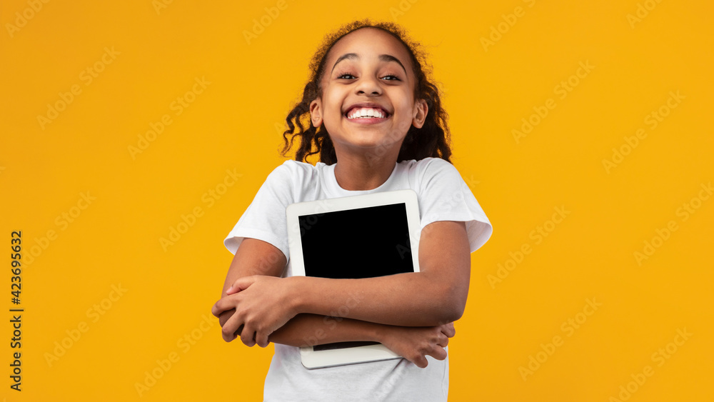 Technology Lover. Excited black girl hugging tablet Technology Lover. Excited black girl hugging tablet