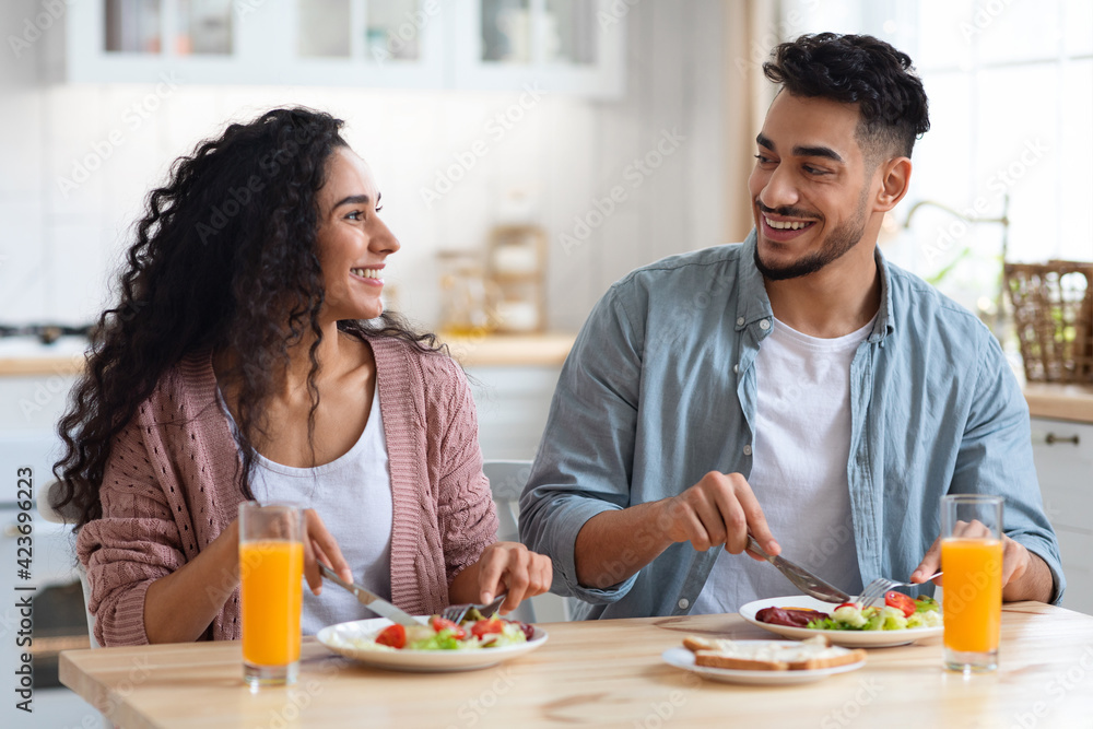 Happy young arab couple enjoying eating their breakfast together Happy young arab couple enjoying eating their breakfast together