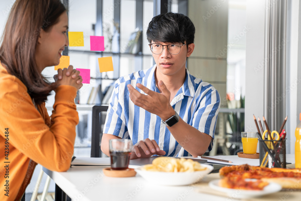 Business team workers discussing work and prepare pizza and potato chips to sharing meal at lunch break for good relations in office. Business team workers discussing work and prepare pizza and potato chips to sharing meal at lunch break for good relations in office.