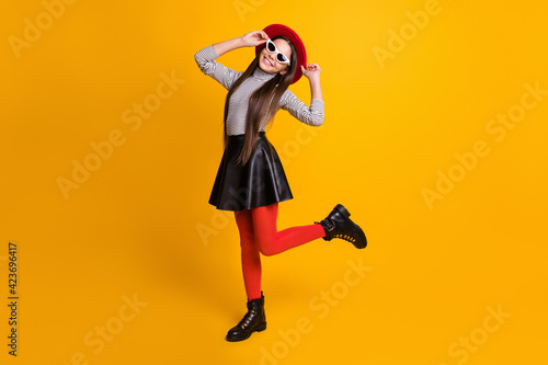 Full length body size view of pretty trendy cheerful girl posing dancing having fun touching hat isolated on bright yellow color background