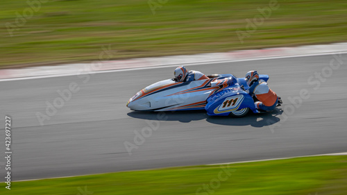 Foto A panning shot of a racing sidecar as it corners on a track.