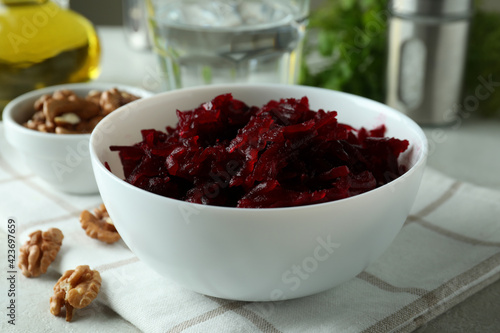 Concept of tasty eating with bowl of beet salad on white textured table