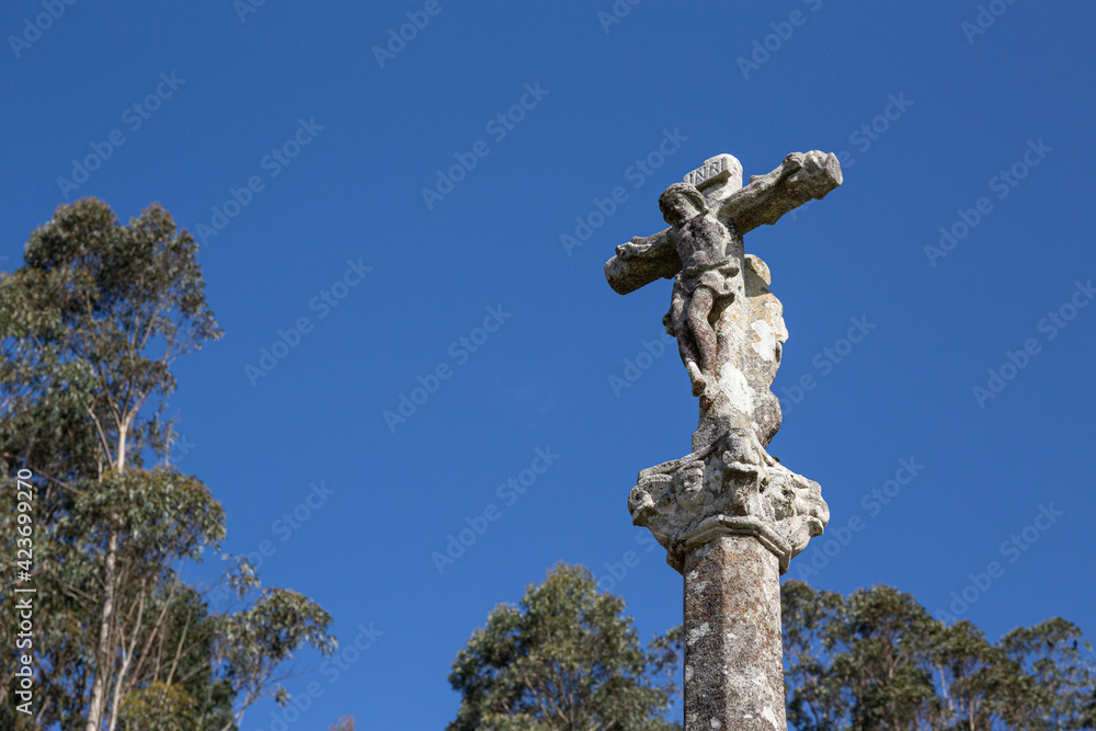 Antique carved stone cross called Cruceiro. Galicia, Spain. Low angle. Copy space