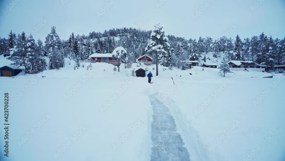 Man Sled Shoveling Mass Of Snow In Winter Foreground Making A Pathway At Rural Area Near Trondheim, Norway. - Static Wide Shot Man Sled Shoveling Mass Of Snow In Winter Foreground Making A Pathway At Rural Area Near Trondheim, Norway. - Static Wide Shot