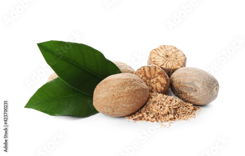 Grated nutmeg and seeds with green leaves on white background