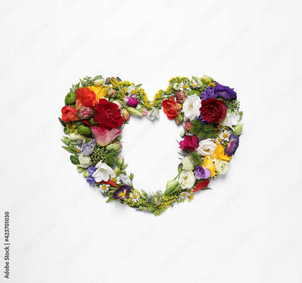 Beautiful heart made of different flowers on white background, top view Beautiful heart made of different flowers on white background, top view