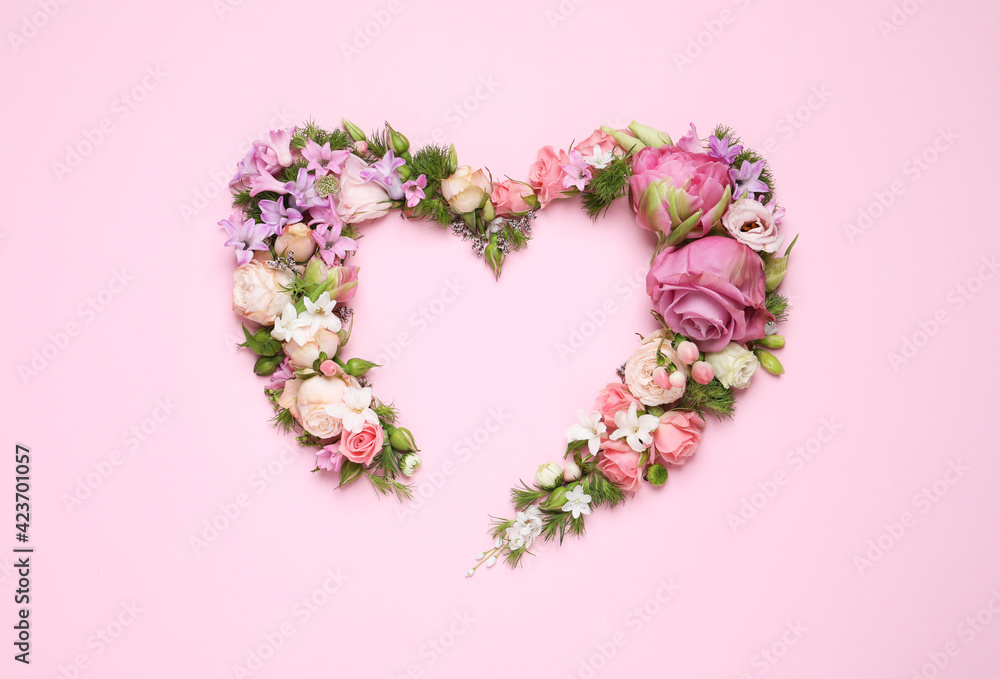 Beautiful heart made of different flowers on pink background, flat lay. Space for text