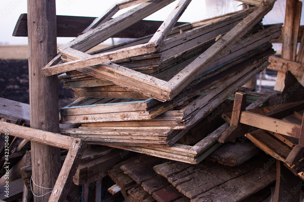 Old windows and wood boards lie on the street as garbage. Firewood for heating from garbage. Old windows and wood boards lie on the street as garbage. Firewood for heating from garbage.