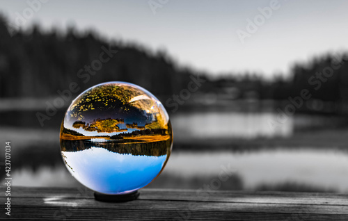 Crystal ball alpine landscape shot with black and white background outside the sphere at the famous Grosser Arbersee, Bayerisch Eisenstein, Bavarian forest, Bavaria, Germany © Martin Erdniss