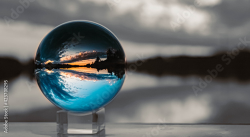 Crystal ball sunset landscape shot with black and white background outside the sphere and reflections near Plattling  Isar  Bavaria  Germany