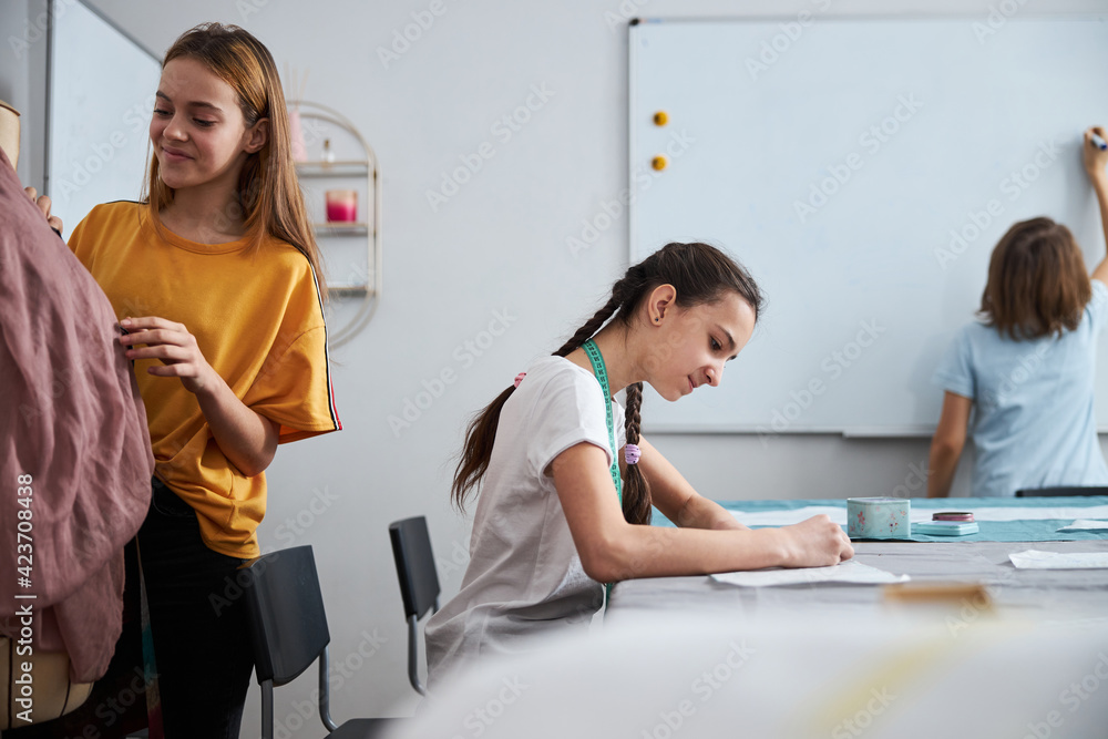 Cute little seamstresses working in sewing workshop Cute little seamstresses working in sewing workshop