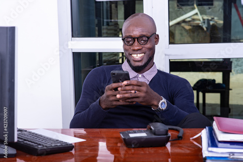 happy adult businessman using mobile phone in office.