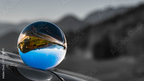 Crystal ball alpine landscape shot with black and white background outside the sphere at the famous Rossfeldstrasse near Berchtesgaden, Bavaria, Germany © Martin Erdniss