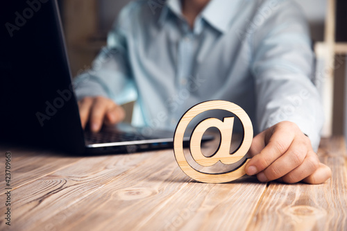 man holding wooden mail icon