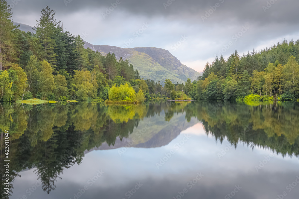 Calm, idyllic mountain landscape lake reflection on Glencoe Lochan on a summer evening in the Scottish Highlands, Scotland.