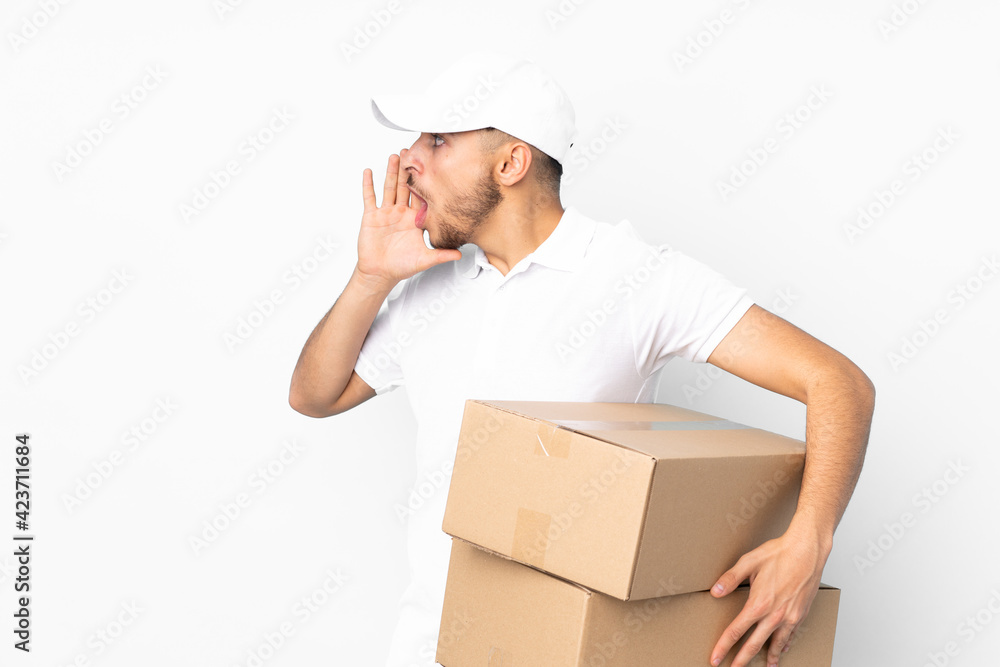 Delivery Arabian man isolated on blue background shouting with mouth wide open Delivery Arabian man isolated on blue background shouting with mouth wide open