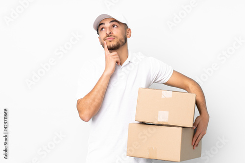 Delivery Arabian man isolated on blue background thinking an idea