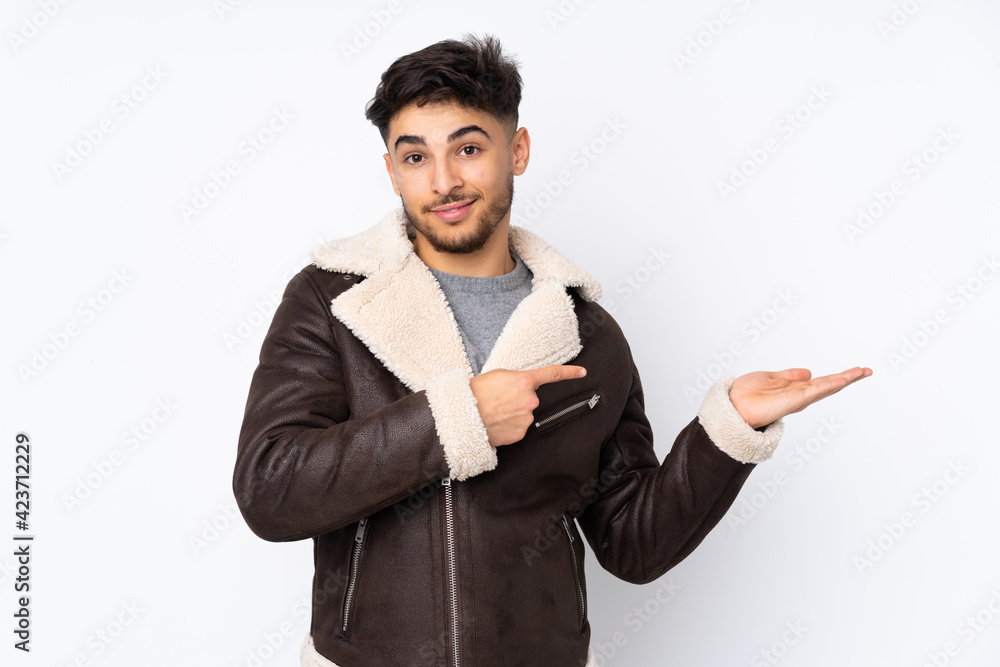 Arabian handsome man over isolated background holding copyspace imaginary on the palm to insert an ad Arabian handsome man over isolated background holding copyspace imaginary on the palm to insert an ad