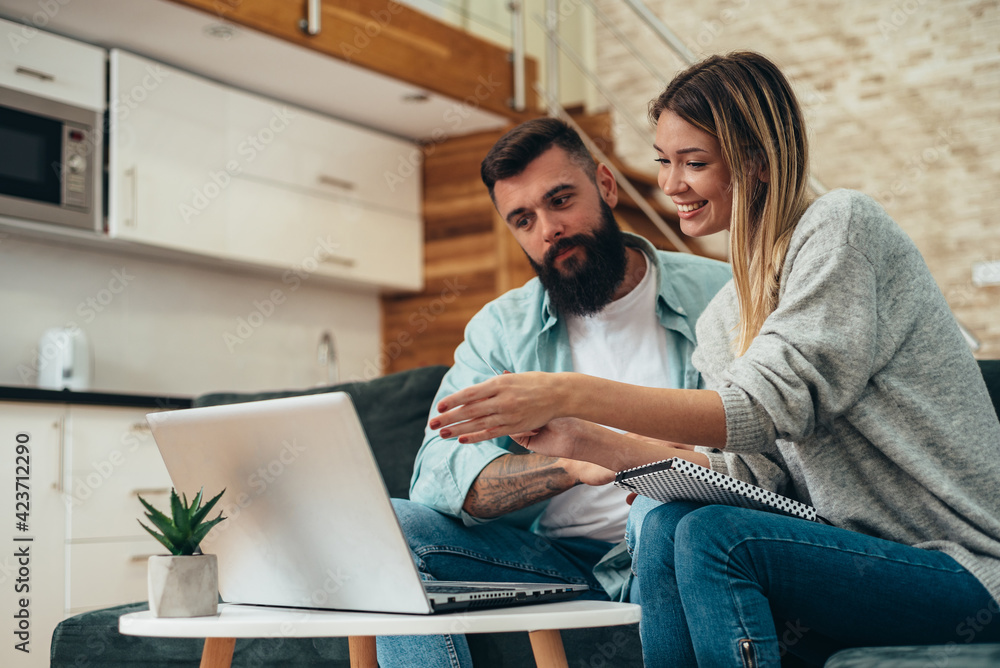 Couple using laptop for online shopping from home Couple using laptop for online shopping from home