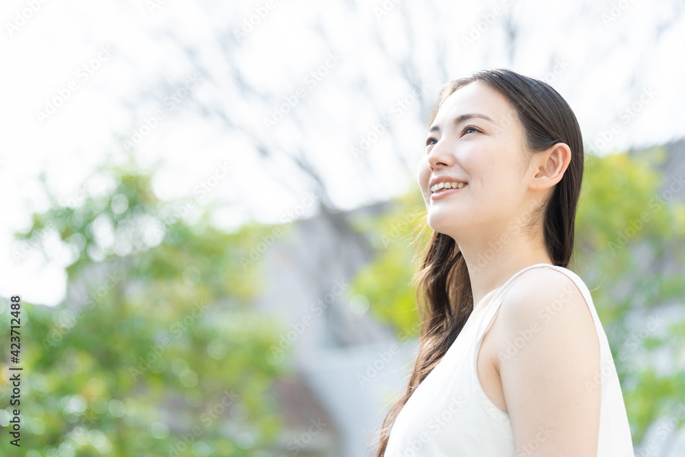 公園でリラックスする若い女性 公園でリラックスする若い女性