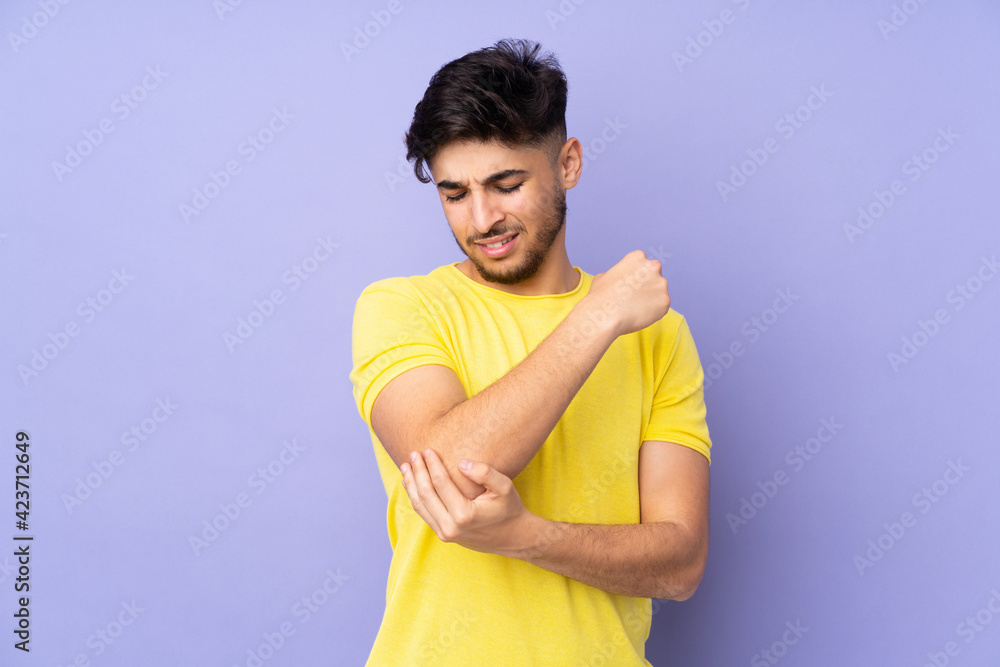 Arabian handsome man over isolated background with pain in elbow Arabian handsome man over isolated background with pain in elbow