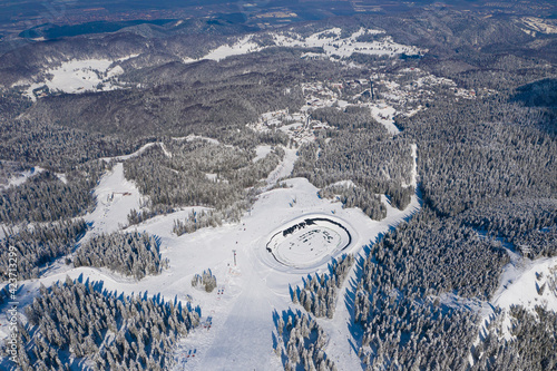 Aerial view of Poiana Brasov ski resort from Postavaru Mountains in Romania. Landmark of winter sports. photo