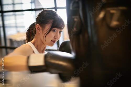 トレーニングジムでキックボクシングをするアジア人女性