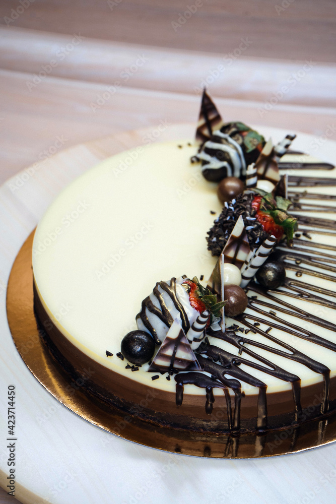 Chocolate cake cheesecake decorated with chocolates and strawberries