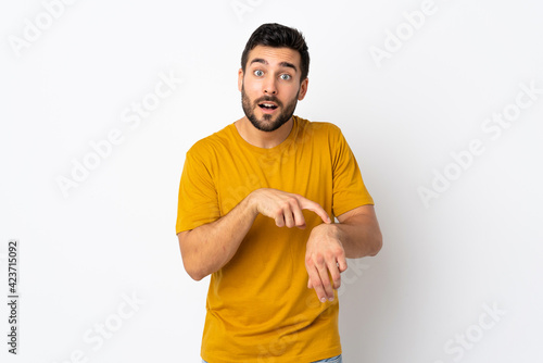 Young handsome man with beard isolated on white background making the gesture of being late