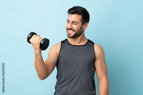 Young sport man with beard making weightlifting with happy expression