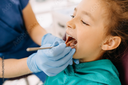 Closeup of a little girl at a dental clinic at a checkup. Patient at a dentist.