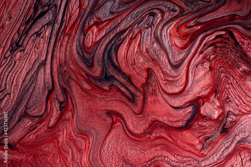 Textured stains of liquid nail polish,fluid art technique.Red color.Shimmer marble background.Stripy paint texture.Nail lacquer flow modern backdrop. Minimalism concept.Copy space,horizontal photo.