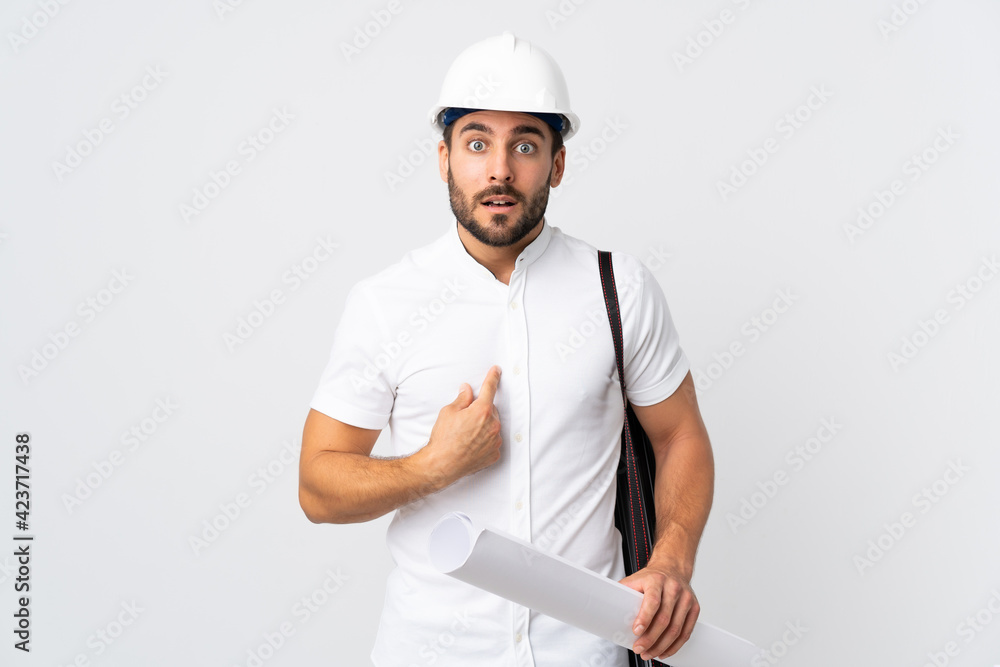 Young architect man with helmet and holding blueprints isolated on white background pointing to oneself Young architect man with helmet and holding blueprints isolated on white background pointing to oneself