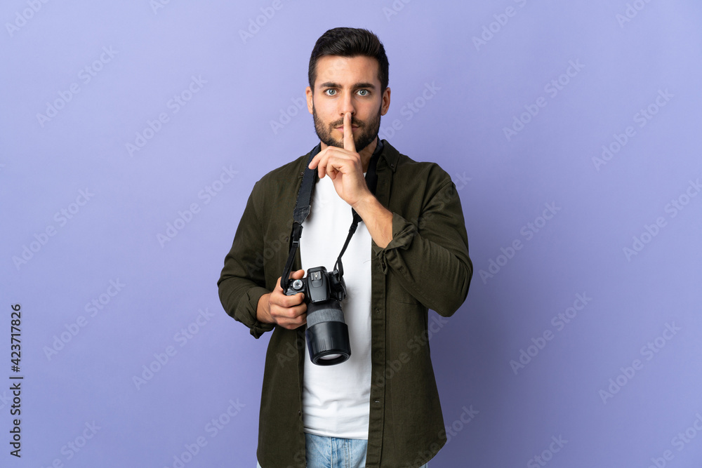 Naklejka premium Photographer man over isolated purple background showing a sign of silence gesture putting finger in mouth