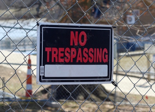 A close view on the no trespassing sign on the fence.