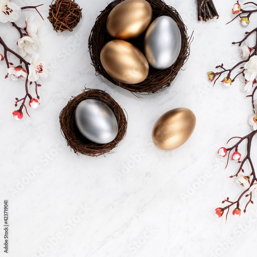 Design concept of Golden and silver Easter eggs in the nest with white plum flower.