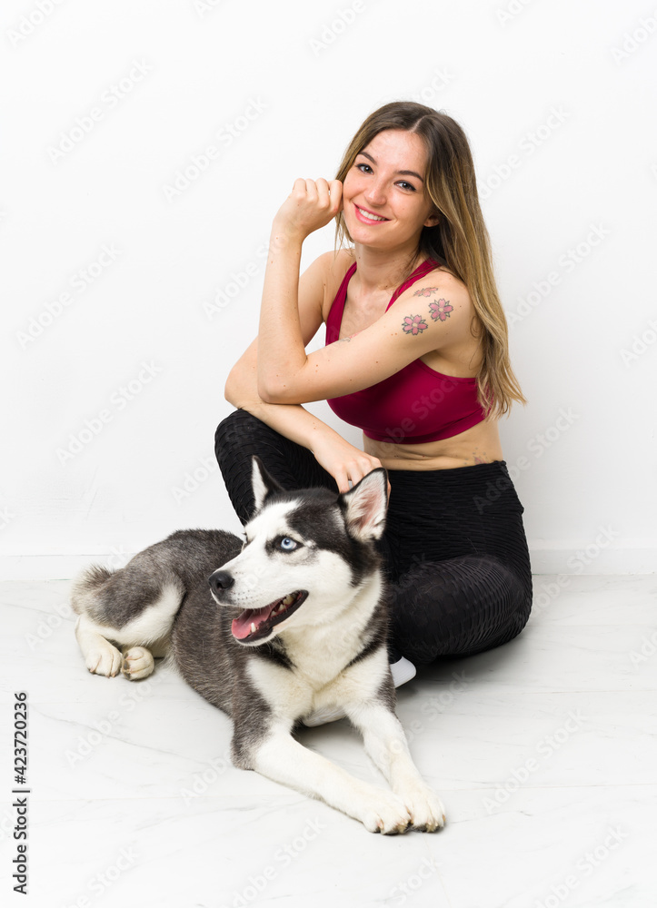 Young sport girl with her dog sitting on the floor